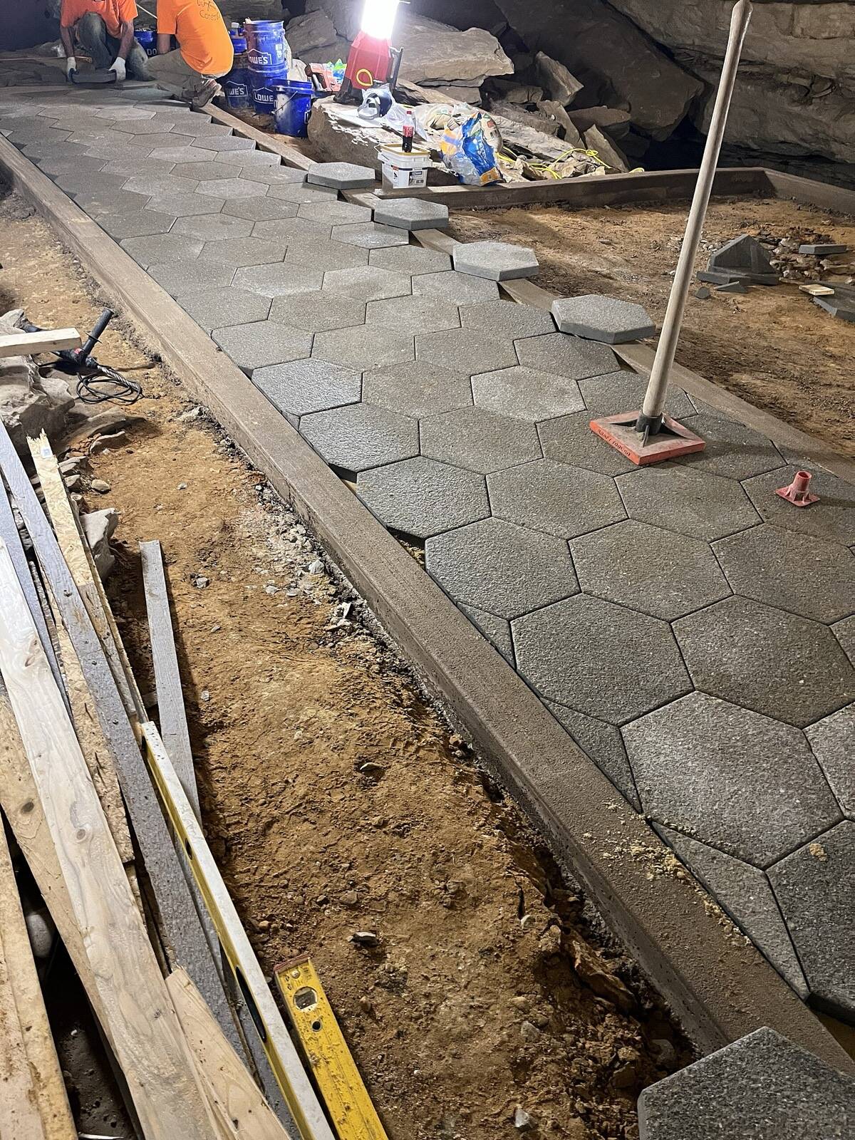 Natuurstenen tegels voor een tuinpad worden in zand gelegd
