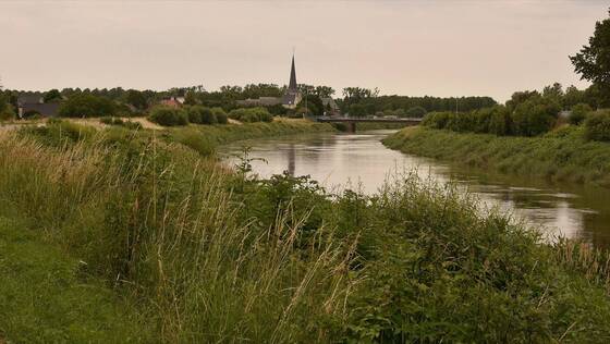 Landschap bij Heffen met een waterloop en de kerktoren in de verte