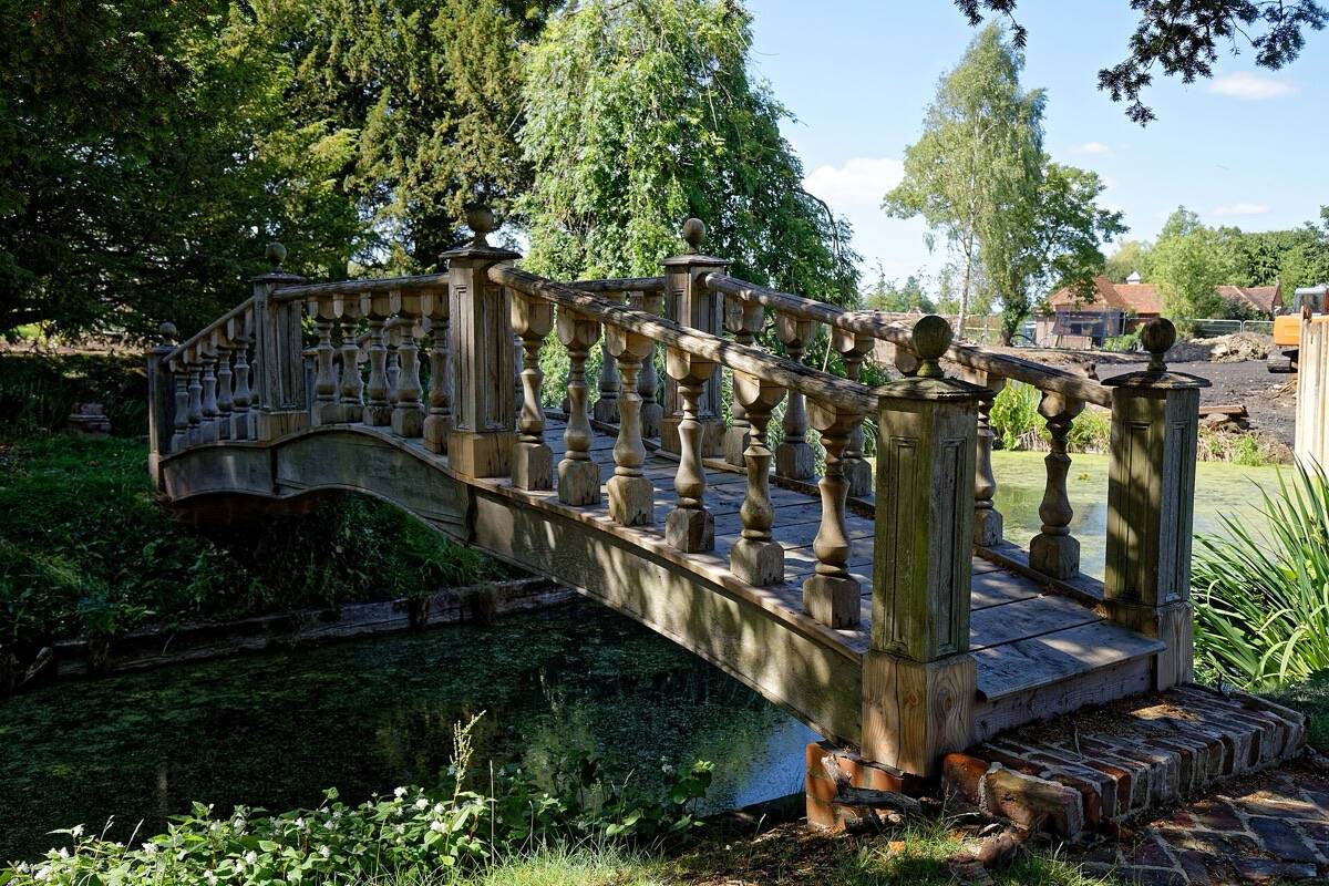 Een houten brug over een tuinvijver